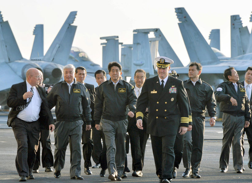 Japan’s former Prime Minister Shinzo Abe and Defence Minister General Nakatani visiting the USS  Ronald Reagan in 2015. If Japan decides to adhere to the TPNW, it will have to provide assurance that its ‘extended deterrence dialogue’ with the United  States would not involve participation in nuclear strike planning.